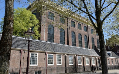 Portuguese Synagogue exterior in Amsterdam with trees and lamppost.