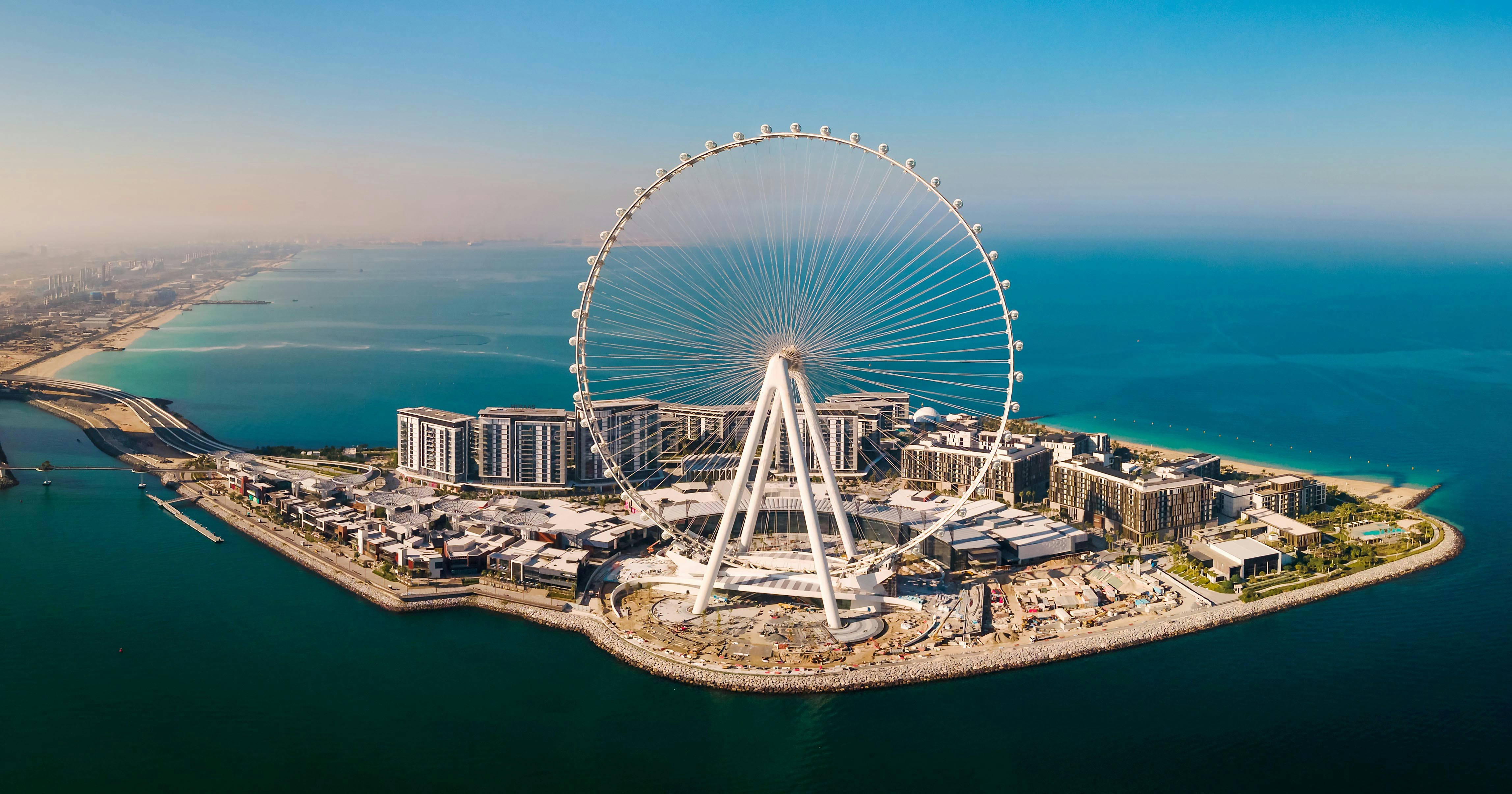Ain Dubai Ferris wheel on Bluewaters Island, Dubai, with cityscape and coastline.