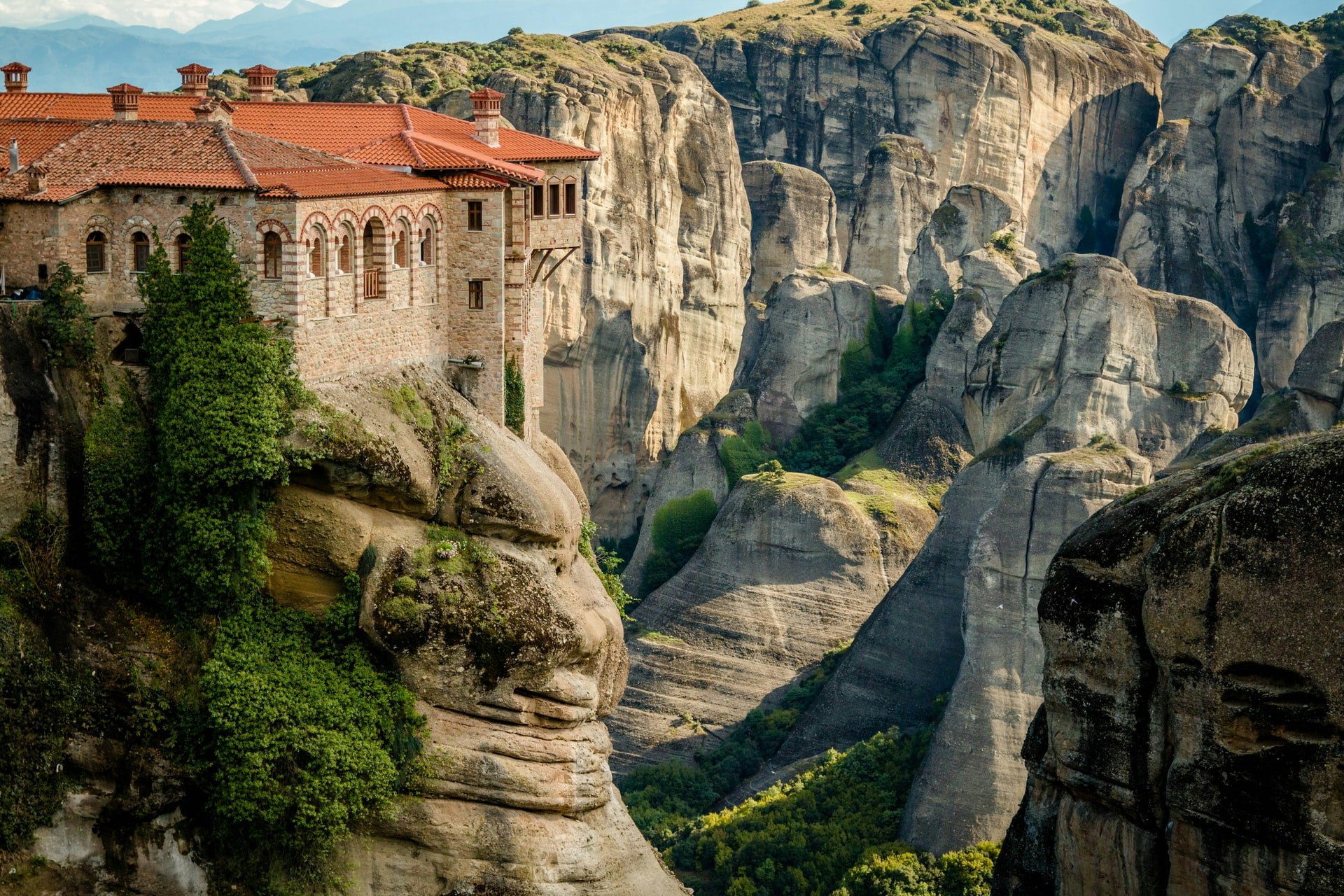 Monastery perched on a cliff in Meteora, Greece, surrounded by rock formations.