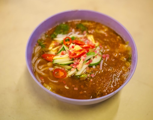 Singapore market stall with various laksa paste jars displayed for sale.