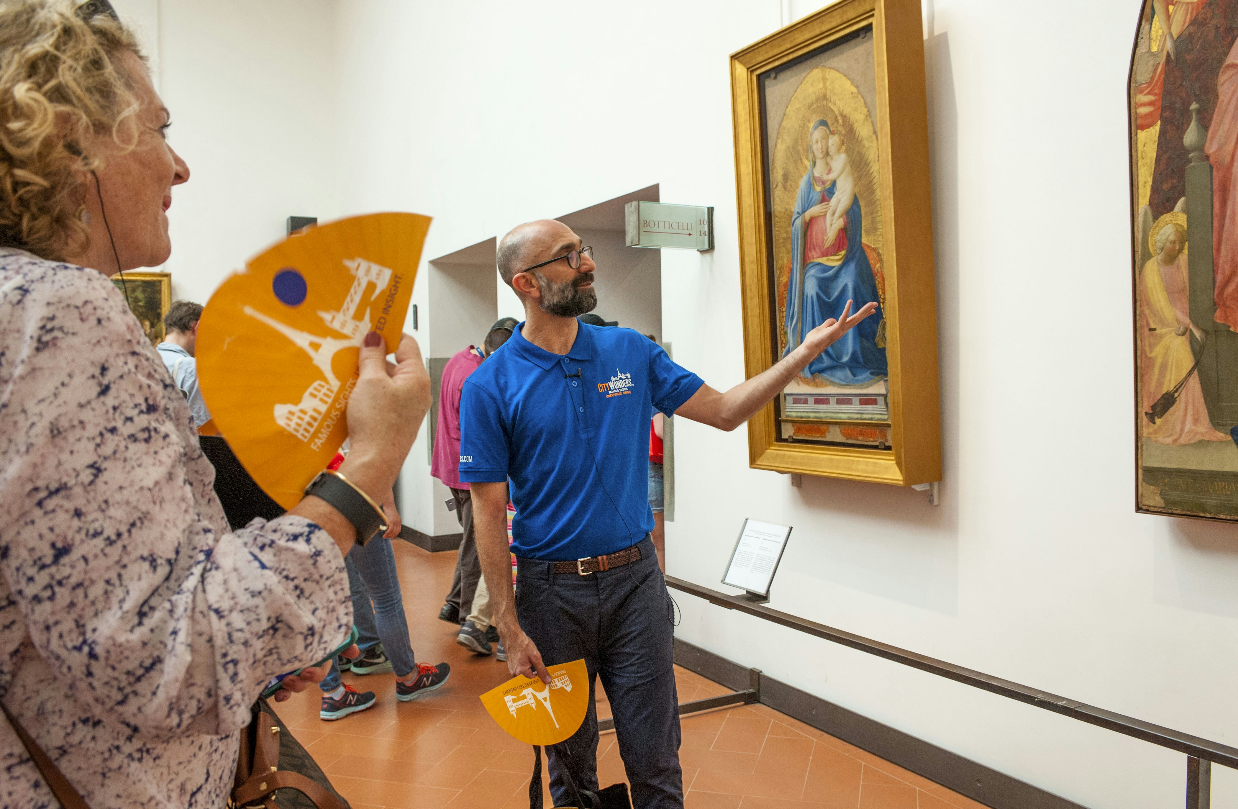 Visitors exploring art exhibits inside Uffizi Gallery, Florence, Italy.