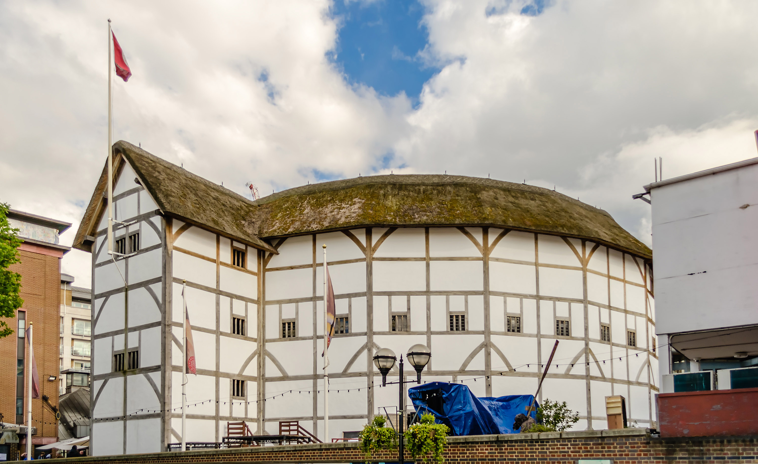 Shakespeare's Globe Theatre in London with tourists exploring the historic site.