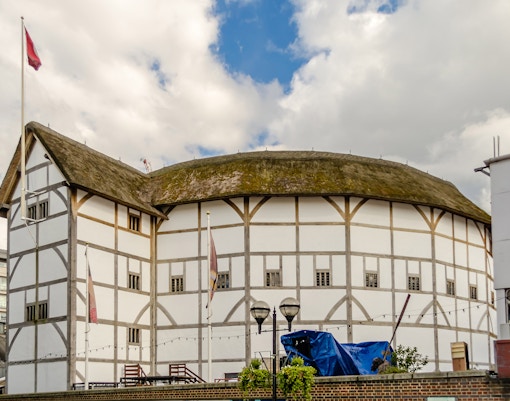 Shakespeare's Globe Theatre in London with tourists exploring the historic site.