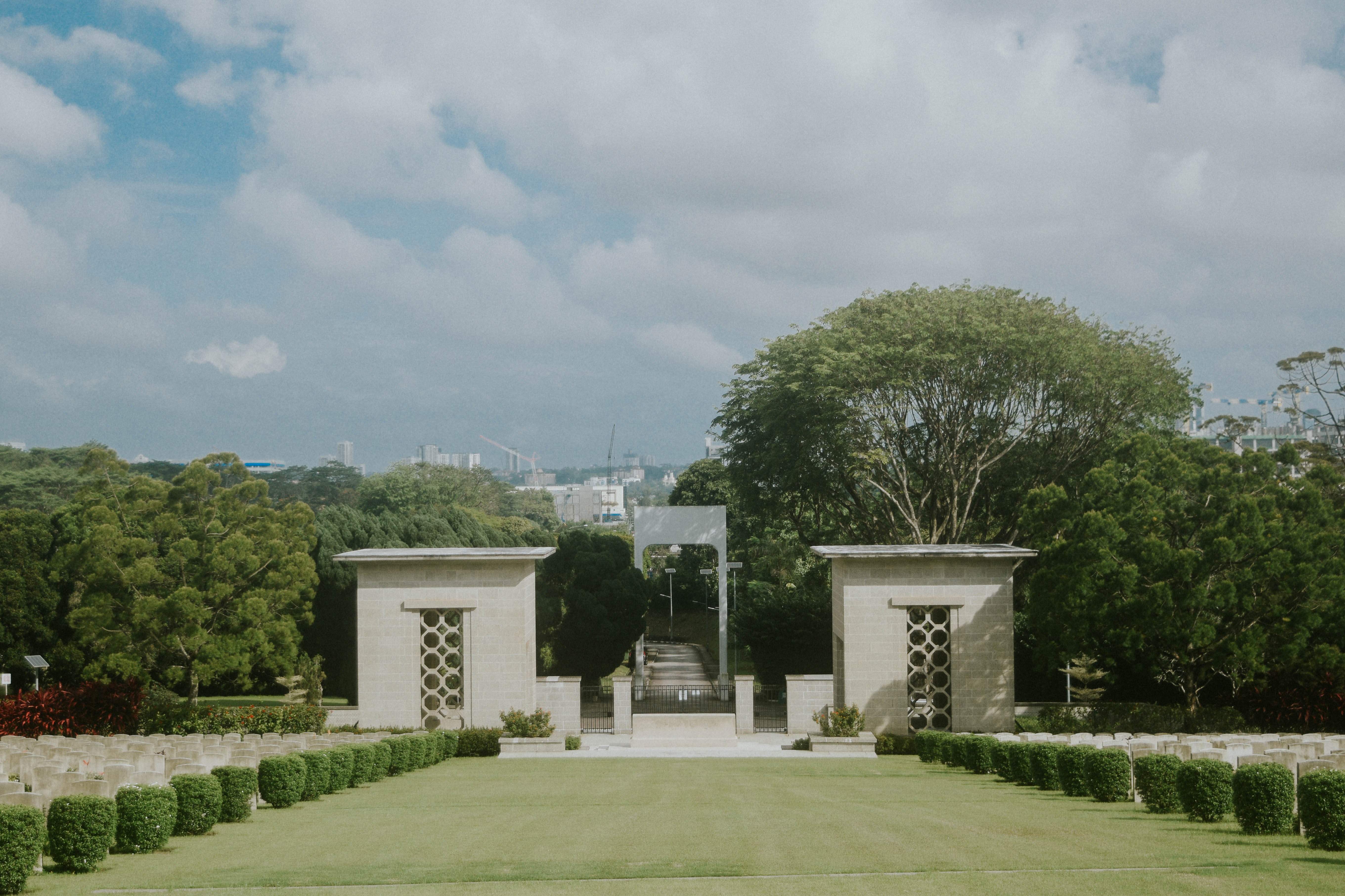 Kranji War Memorial in Singapore with rows of white gravestones and lush green surroundings.