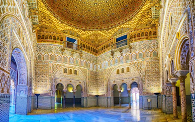 Tourists exploring the ornate archways of the Royal Alcazar of Seville on a guided tour.