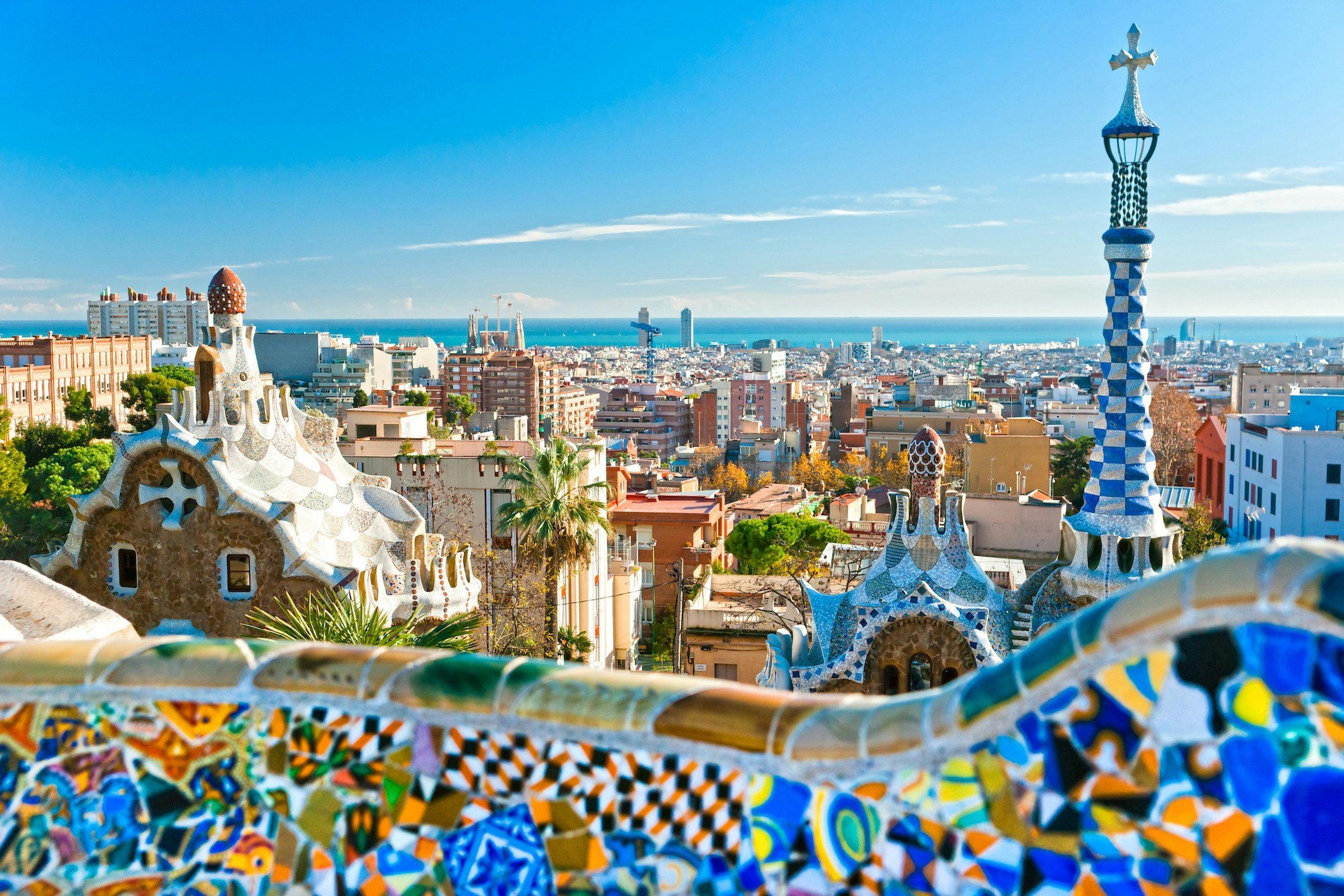 Park Guell mosaic benches with cityscape view in Barcelona, Spain.
