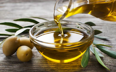 Pouring olive oil into a bowl with olives and leaves, Madrid shopping.