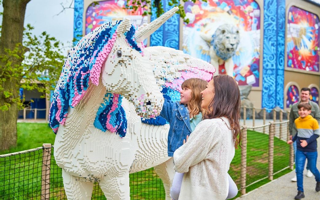 Child and adult admiring Lego unicorn at Legoland Windsor's Lego Mythica.