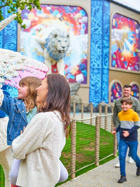 Child and adult admiring Lego unicorn at Legoland Windsor's Lego Mythica.