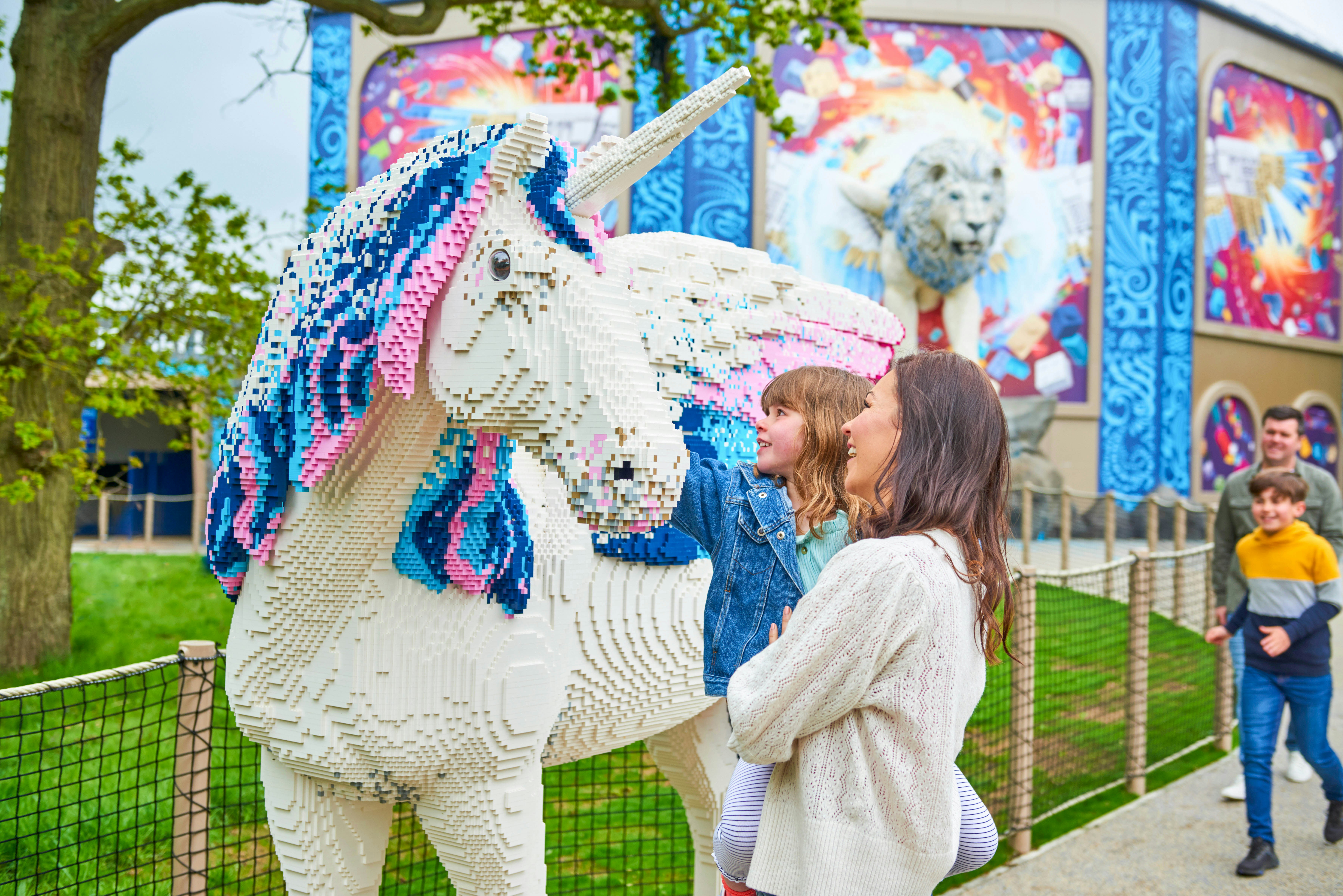 Child and adult admiring Lego unicorn at Legoland Windsor's Lego Mythica.
