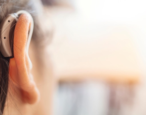 Hearing aid on a person's ear, highlighting accessibility at Orsay Museum.