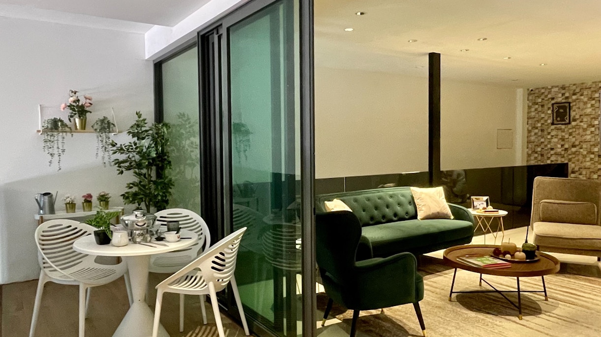 Modern living area in Genting Highlands Hotel with green sofa and dining table.