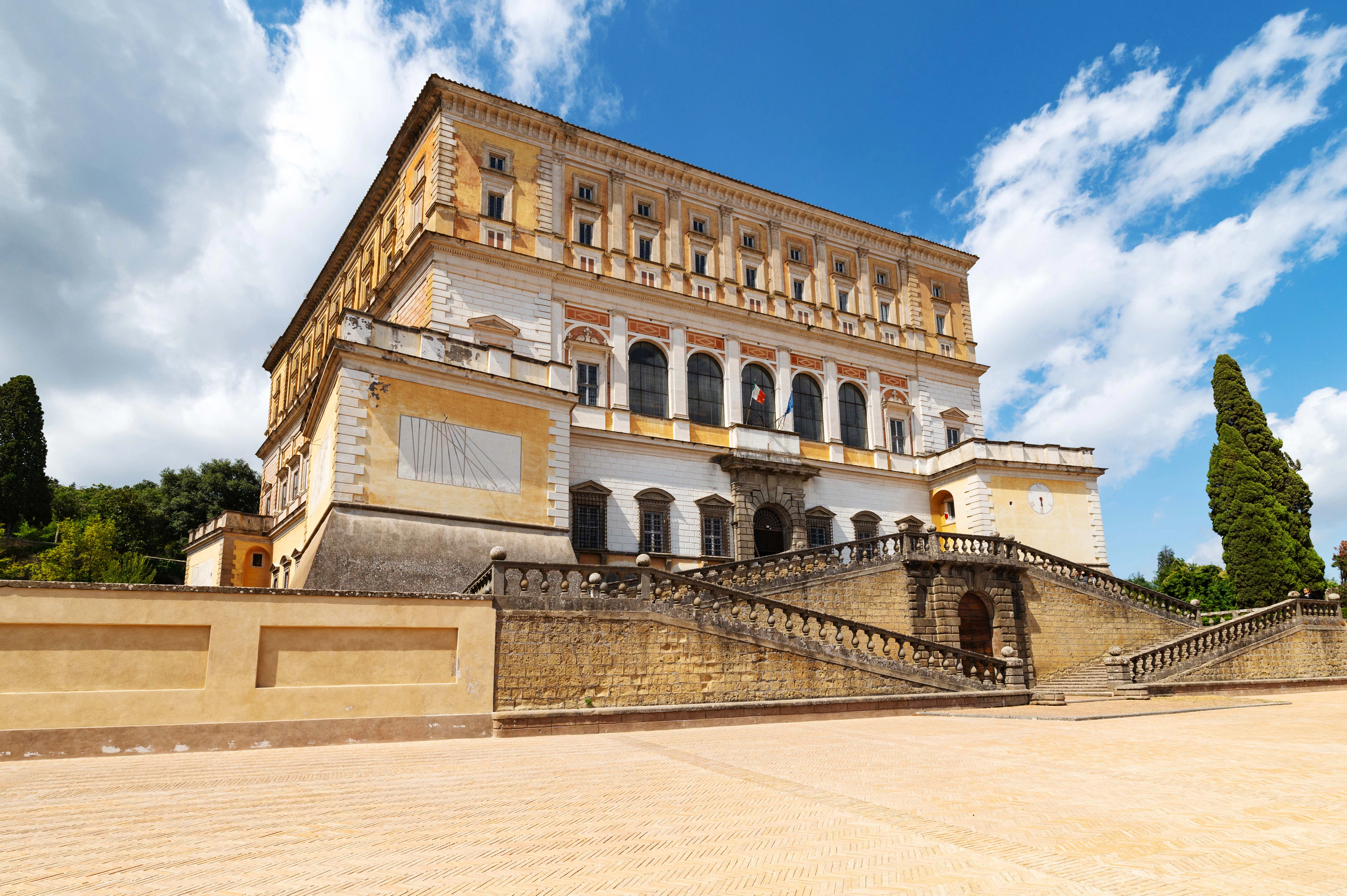 Palazzo Farnese in Rome with grand staircase and Italian flag.