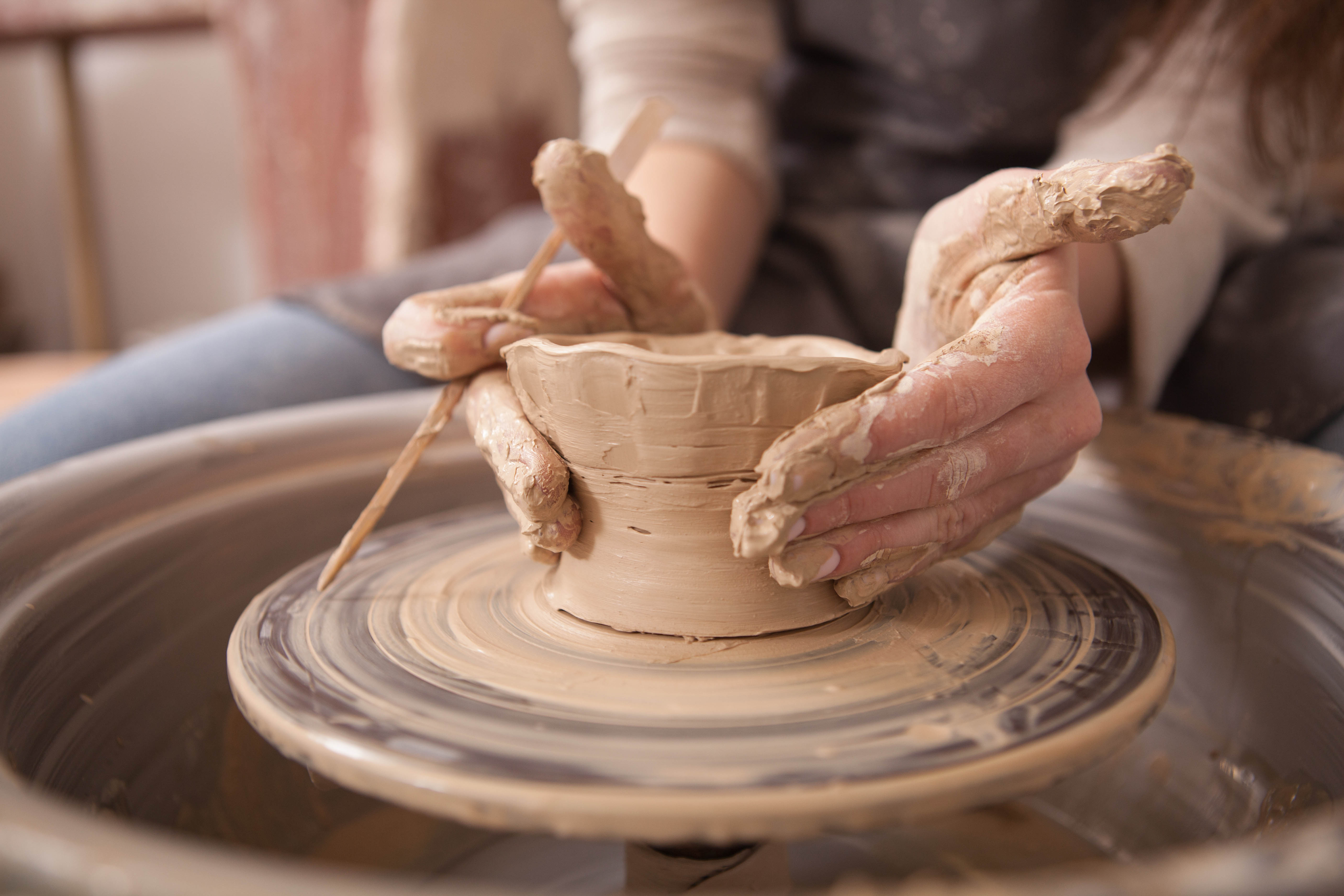 Potter shaping clay on a wheel in a Barcelona ceramics workshop.