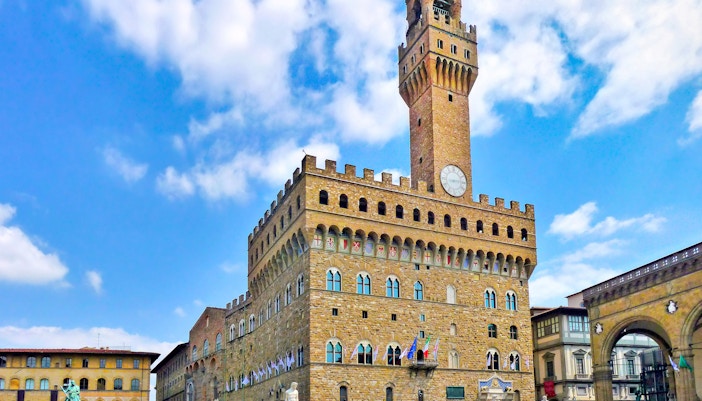 Palazzo Vecchio exterior in Florence during April with tourists exploring the historic site.