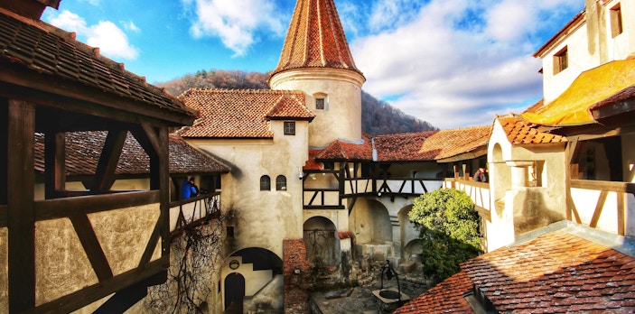 Bran Castle courtyard with medieval architecture and red-tiled roofs in Romania.