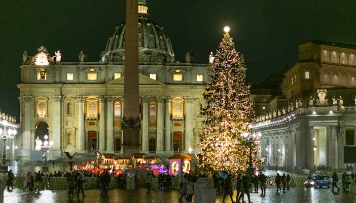 St. Peter’s Basilica with Christmas tree lights in Rome during winter.