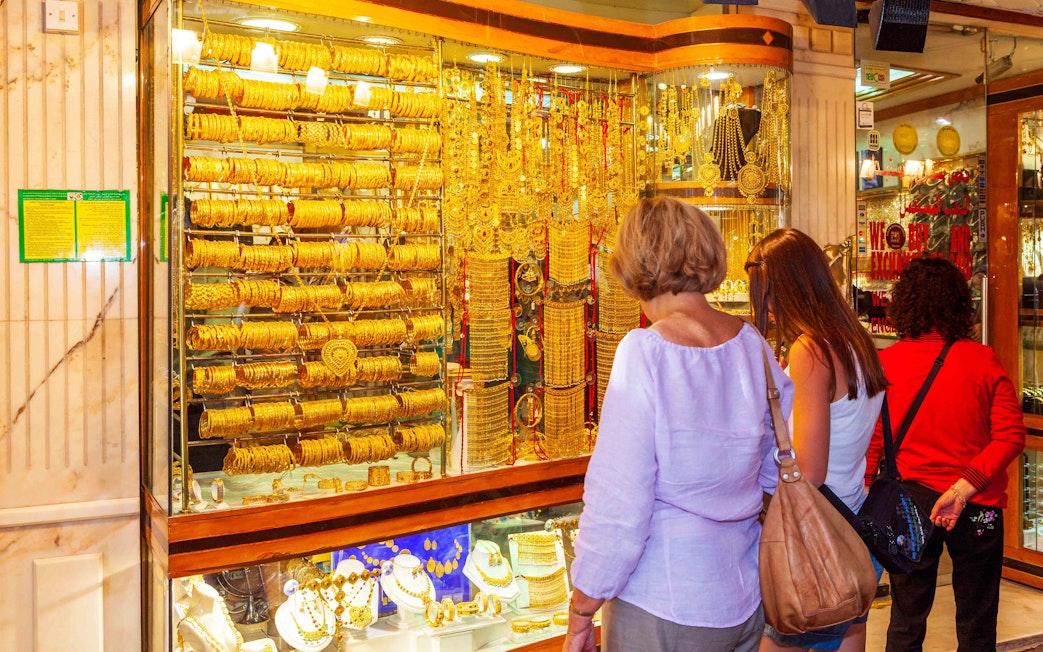 Shoppers browsing gold jewelry at Dubai's Gold Souk.