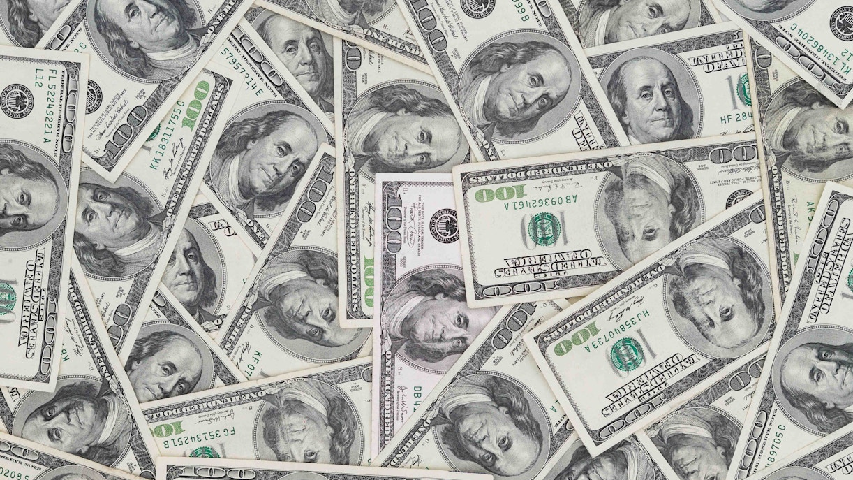 Cash for tips in Hawaii, featuring multiple US hundred-dollar bills.