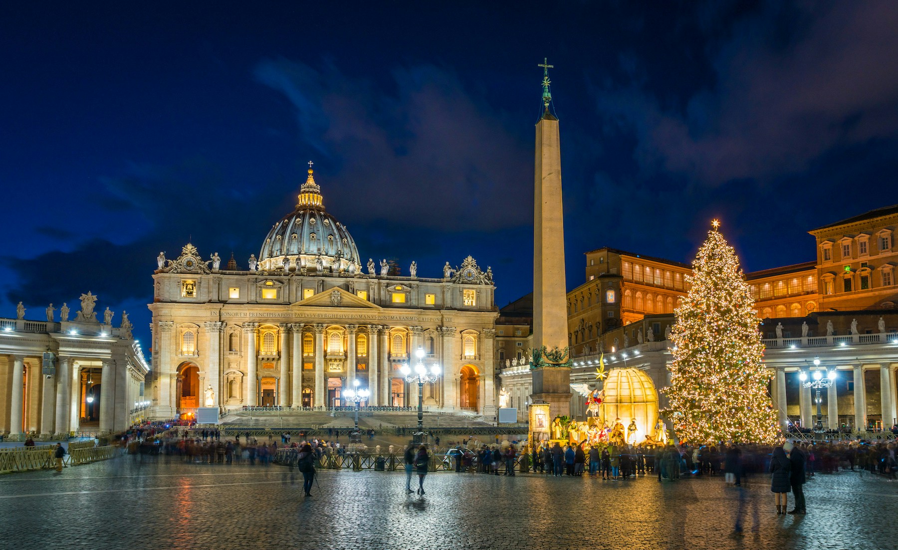 St. Peter's Basilica and Christmas tree in Vatican City, Rome during winter evening.