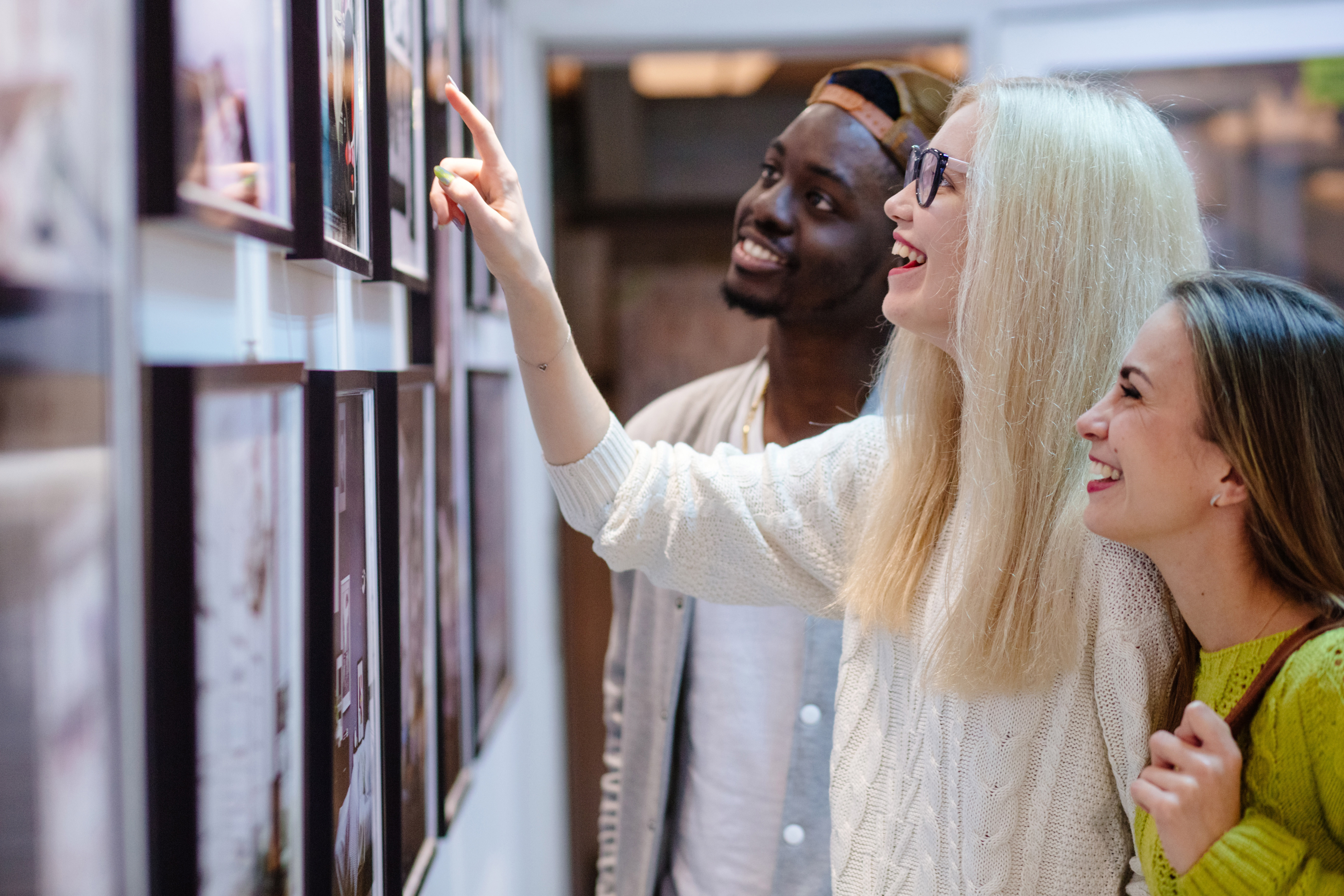 Visitors exploring a vibrant photo exhibition in a modern gallery setting.