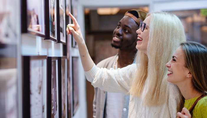 Visitors exploring a vibrant photo exhibition in a modern gallery setting.