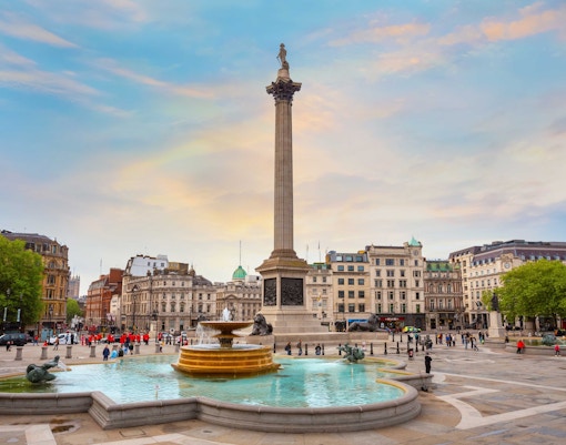 Trafalgar Square view from Hop-on Hop-off London bus with iconic red double-decker and Nelson's Column.