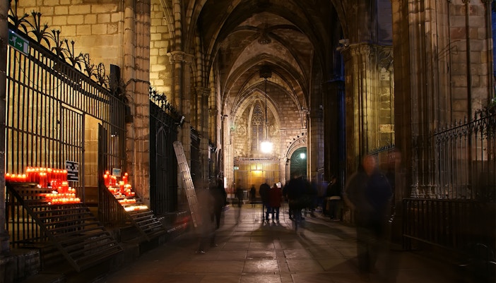 Sagrada Familia crypt interior with intricate stone arches and religious artifacts, Barcelona.