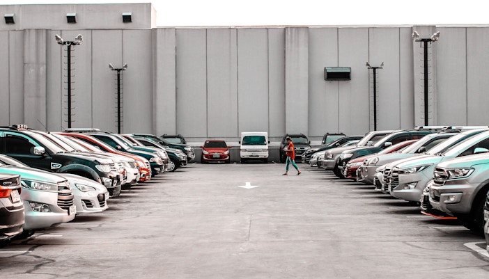 Park Guell parking facilities with cars parked under colorful mosaic structures in Barcelona, Spain.