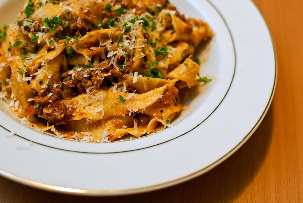 Pappardelle al Cinghiale dish served with wild boar ragu in a traditional Italian setting.