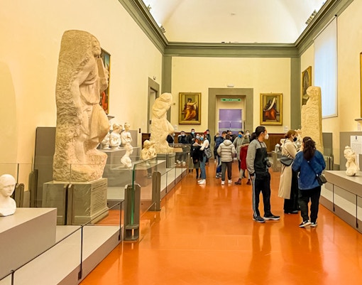 Accademia Gallery's Hall of Prisoners featuring Michelangelo's unfinished sculptures in Florence, Italy.