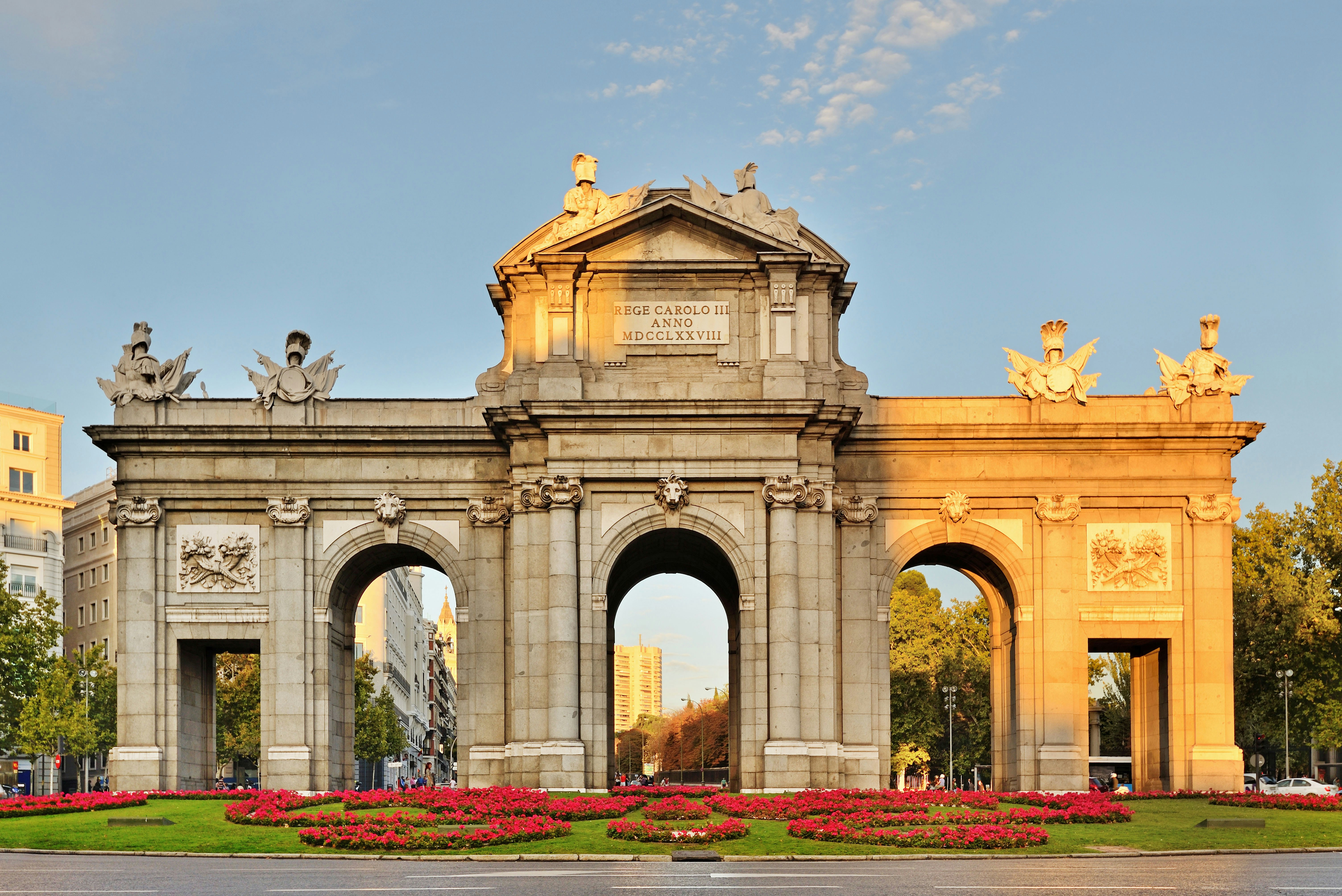 Puerta de Alcalá in Madrid with surrounding traffic and pedestrians.