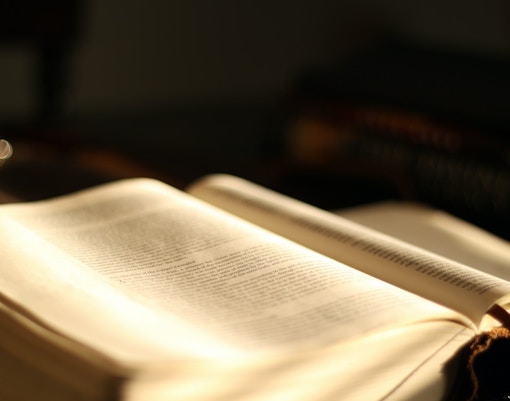 Open book in Vatican Archives with text illuminated by soft light.