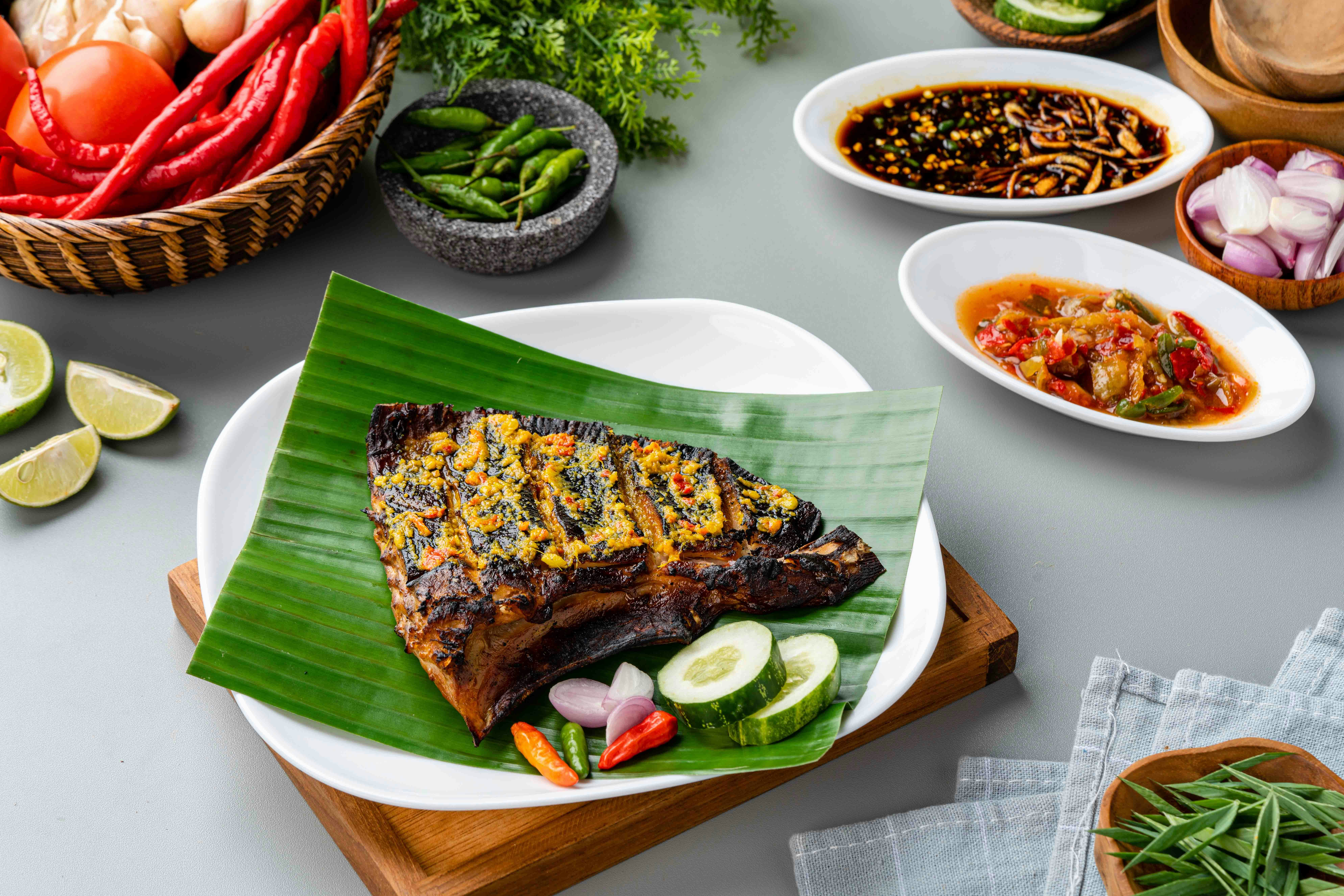 Sambal stingray served on banana leaf at Singapore street food market.