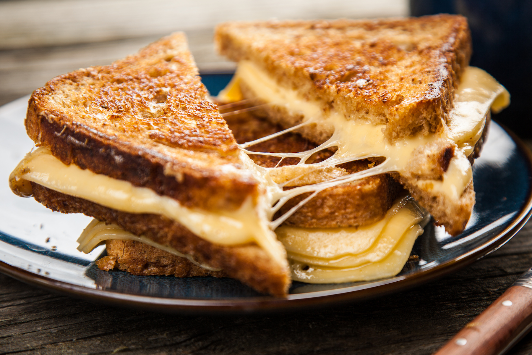 Grilled cheese sandwiches with melted cheese on a plate, London street food.