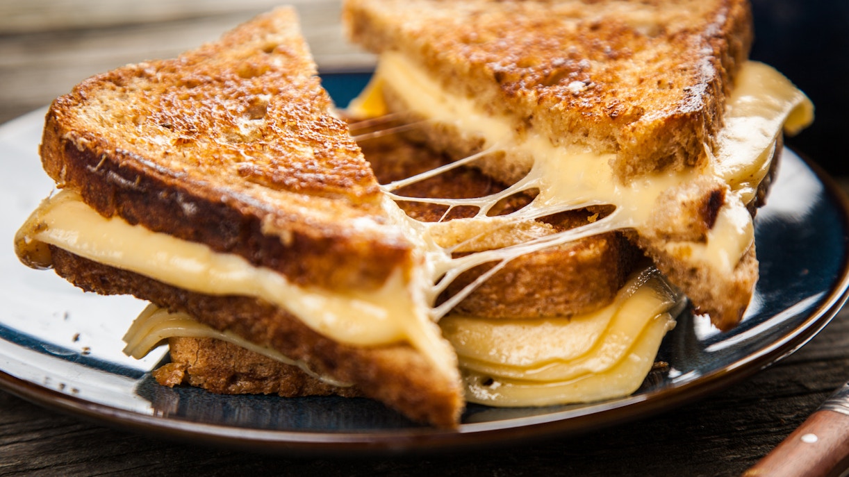 Grilled cheese sandwiches with melted cheese on a plate, London street food.