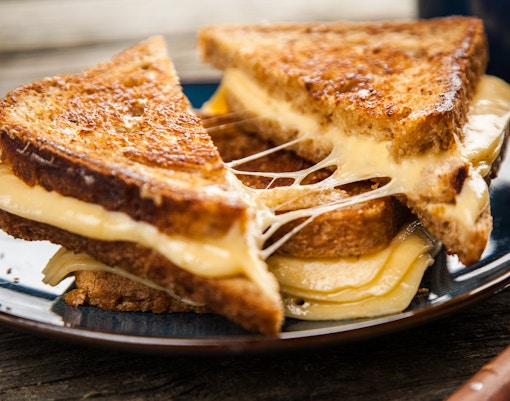 Grilled cheese sandwiches with melted cheese on a plate, London street food.