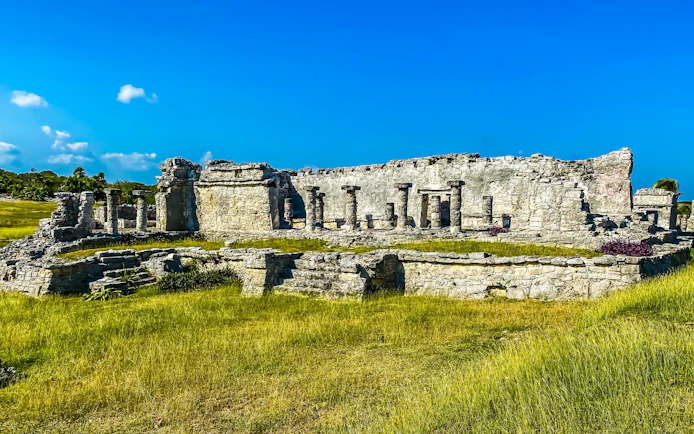 Ancient stone structure at Tulum Ruins, Mexico, under a clear blue sky.