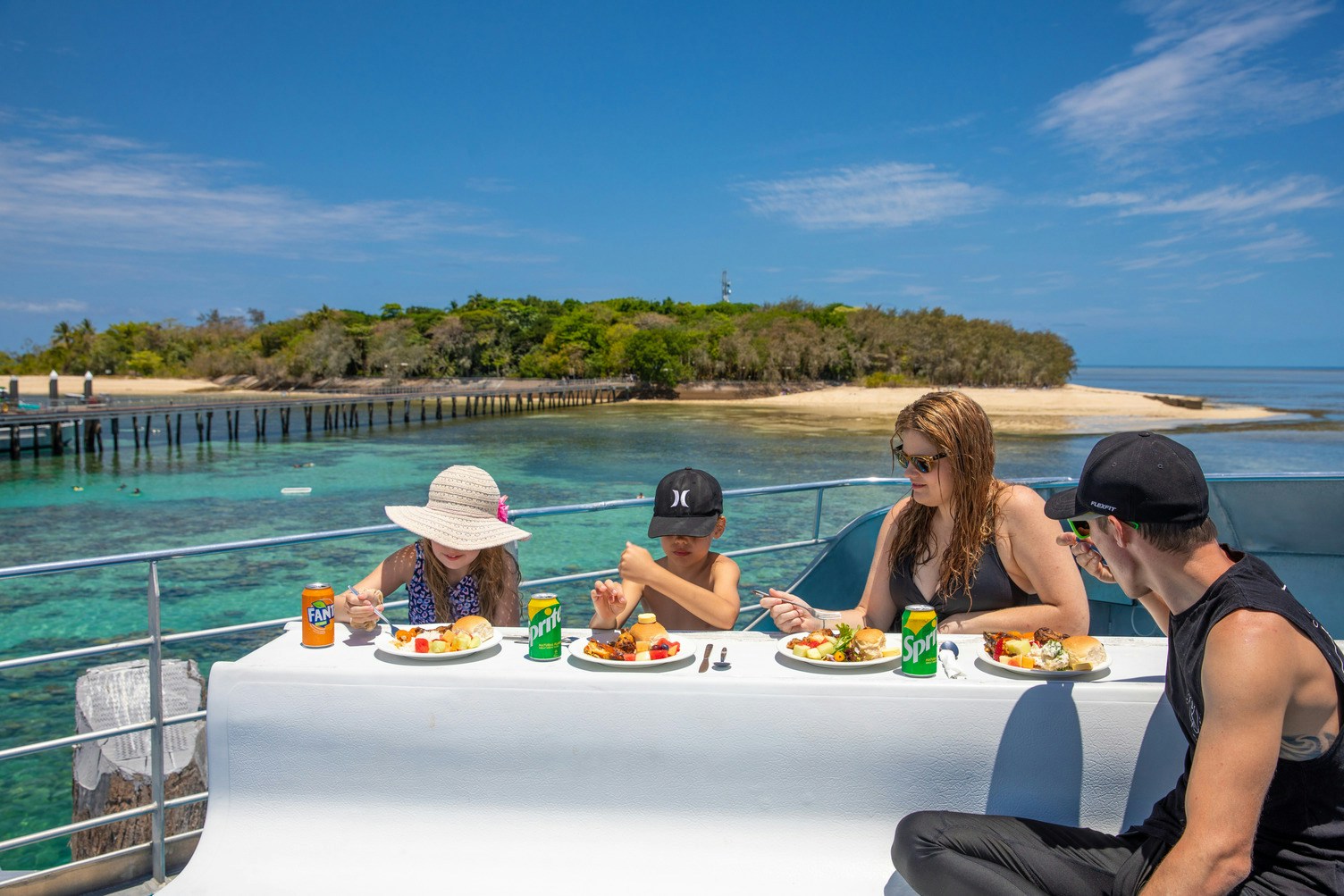 Catamaran sailing near Green Island, Australia, with tourists enjoying the ocean view.