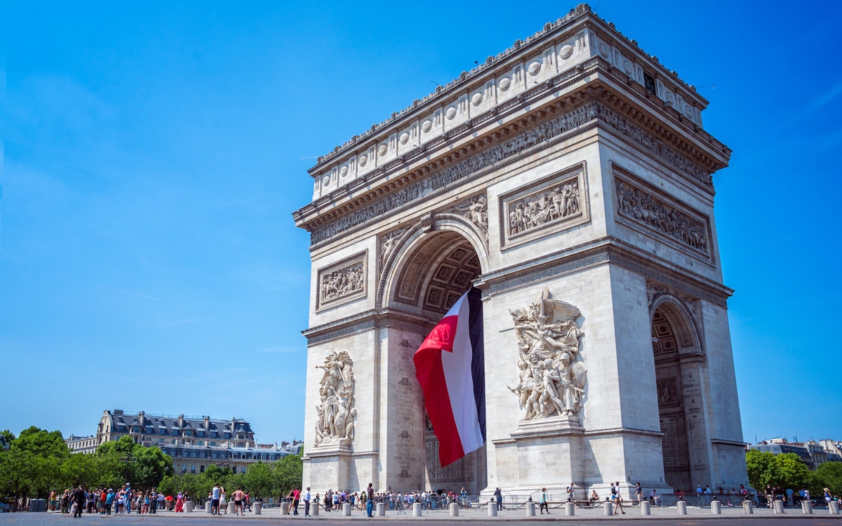 Arc de Triomphe with French flag, Paris, skip the line tickets available.