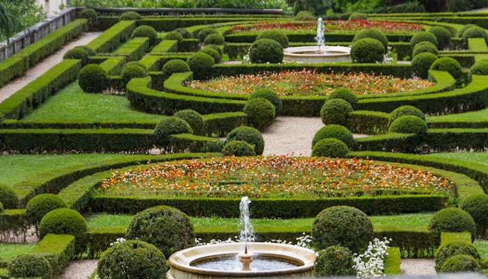 Vatican Gardens with fountains and manicured hedges in Vatican City.