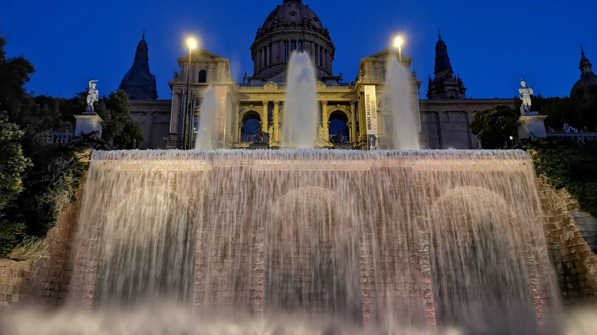 Front view of MNAC in Barcelona with illuminated fountains at night.