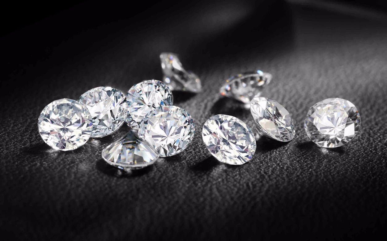 Loose diamonds on a dark surface, related to The Bank Job tour.