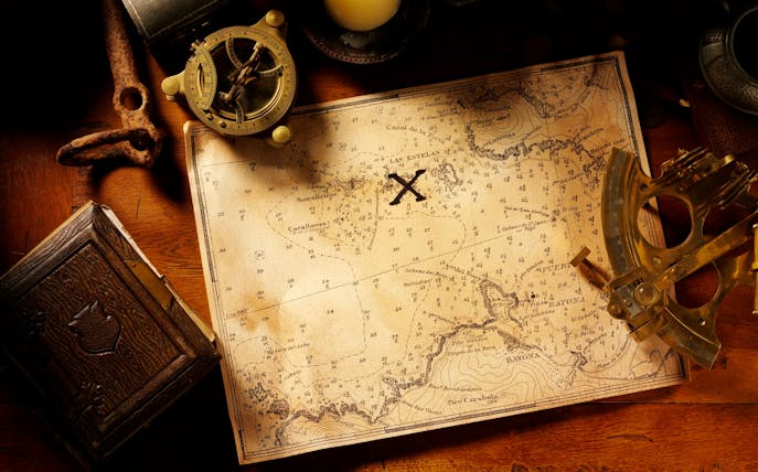 Antique map with compass and sextant, highlighting a marked treasure location for The Bank Job tour.
