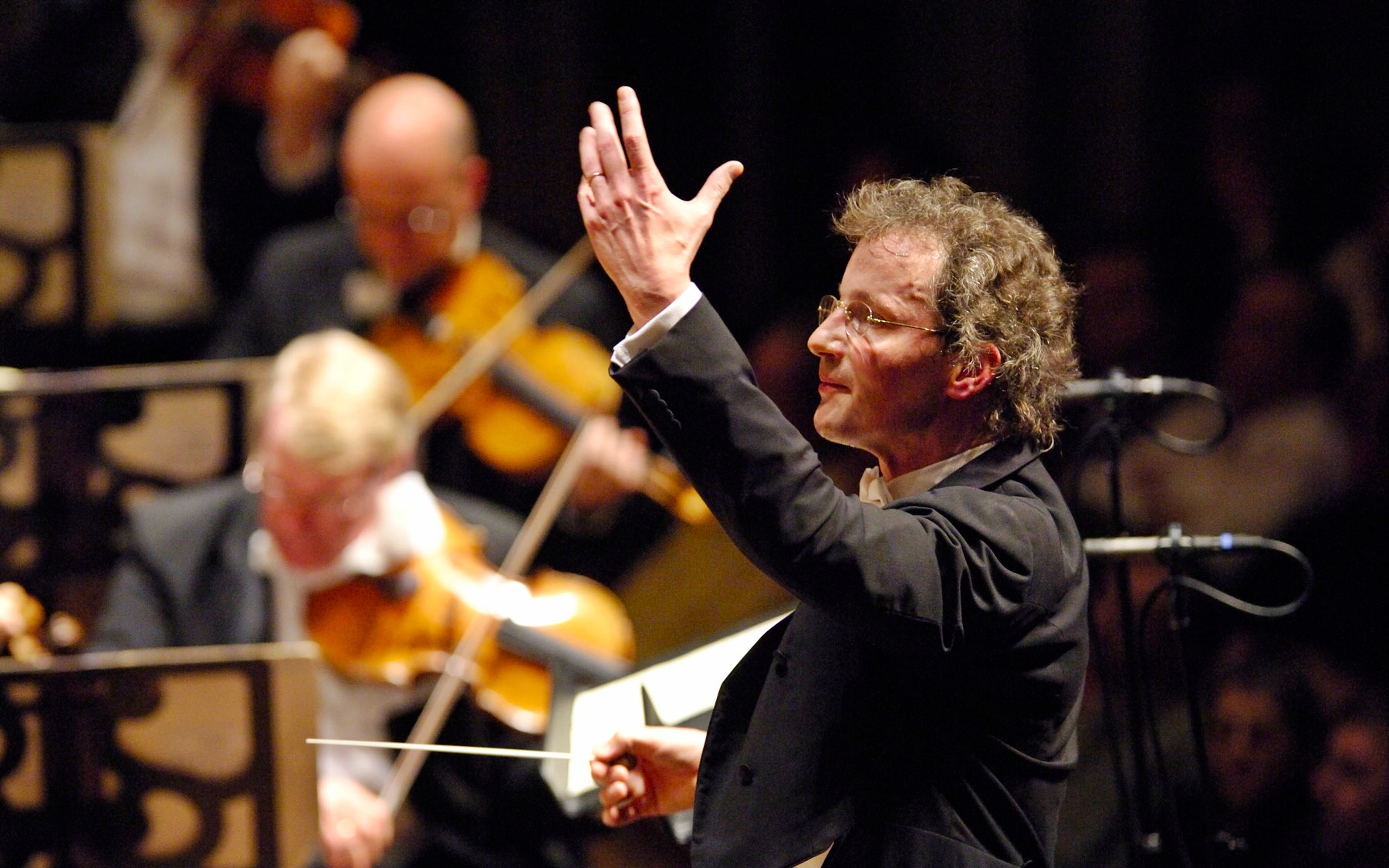 Conductor leading the Vienna Philharmonic Orchestra during a performance.