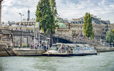 Batobus docked on the Seine River with Eiffel Tower in the background, Paris.