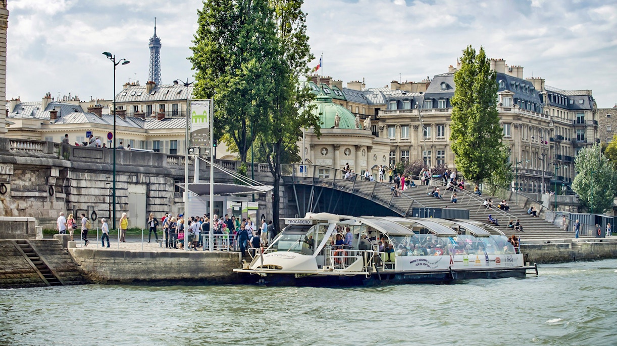 Batobus docked on the Seine River with Eiffel Tower in the background, Paris.
