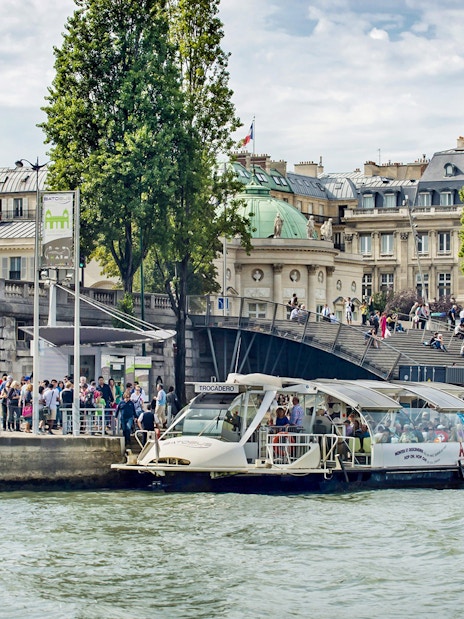 Batobus docked on the Seine River with Eiffel Tower in the background, Paris.
