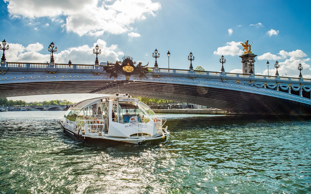 Batobus cruising under Pont Alexandre III in Paris on a sunny day.