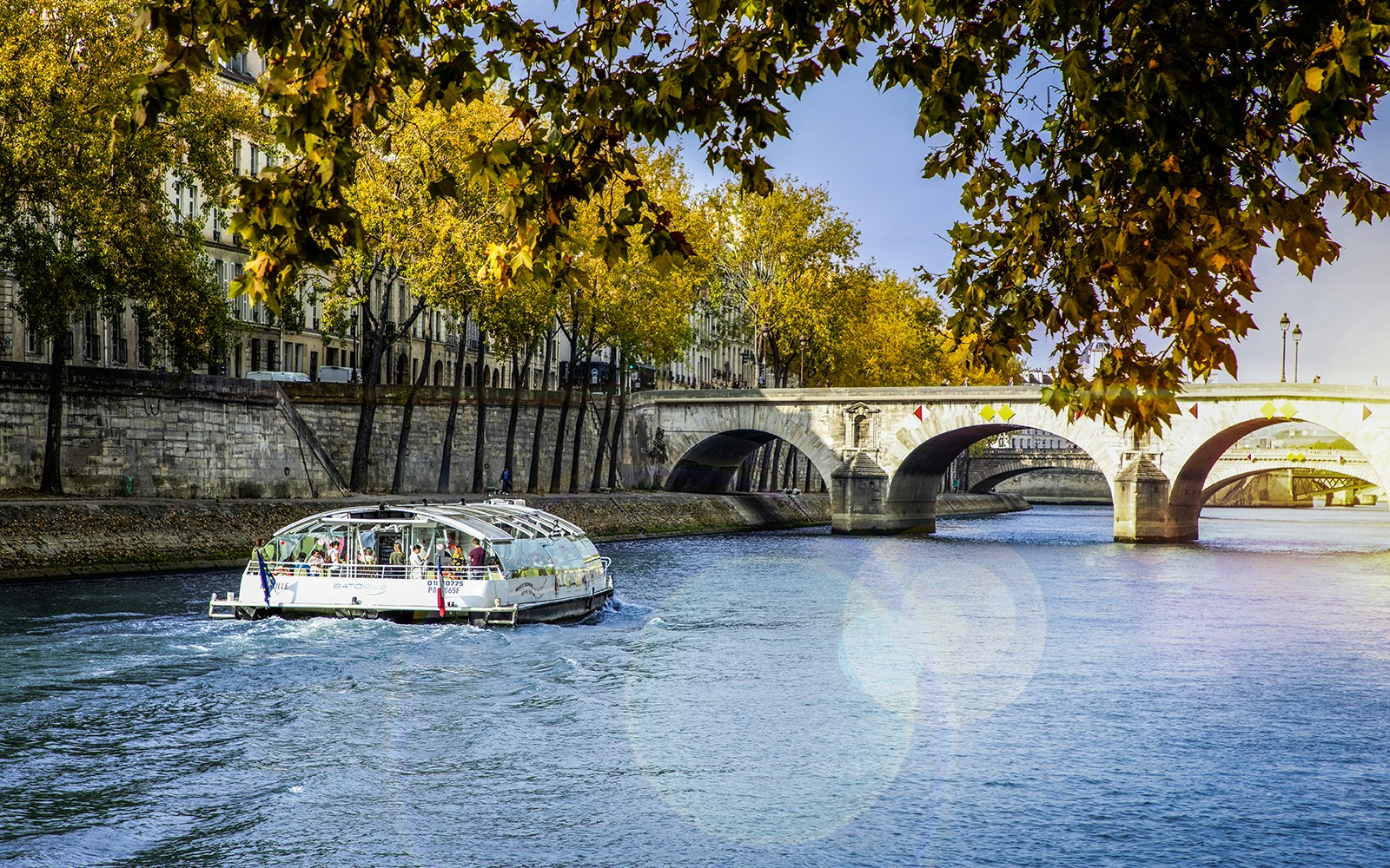 Seine River with Batobus hop-on-hop-off cruise boat near Eiffel Tower, Paris.